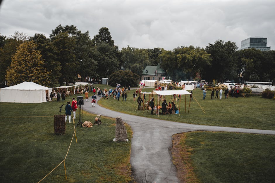 A lively outdoor festival scene with tents and greenery, featuring people in colorful attire.