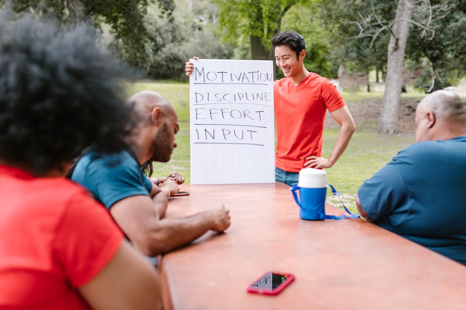 A diverse group of adults engaged in a motivational team building session outdoors.